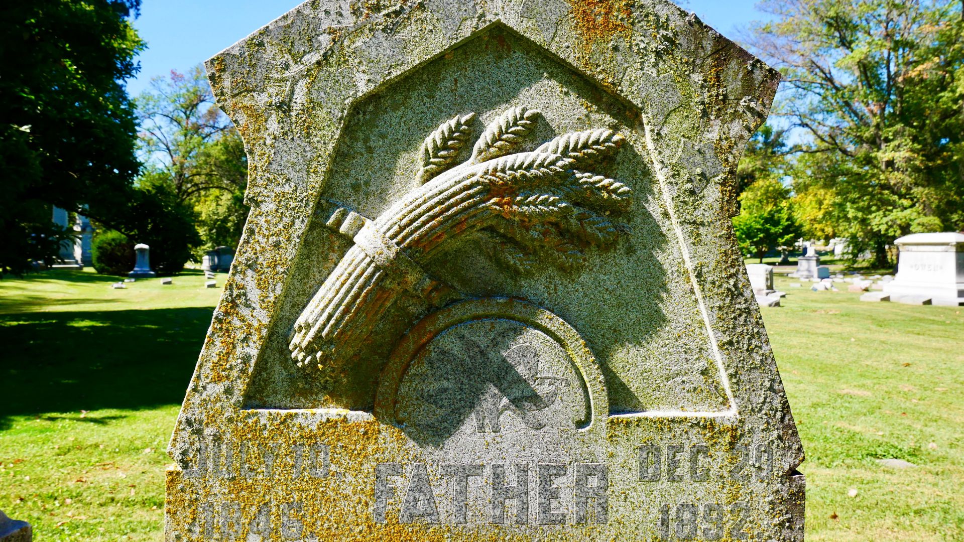 A father's headstone shows a bundle of wheat.
