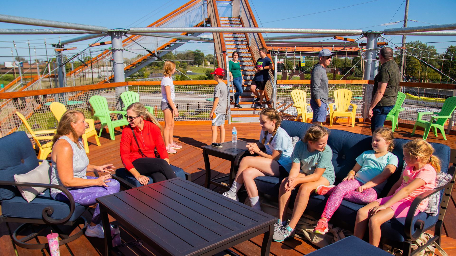 On top of the four-story adventure tower at RYZE Adventure Park, people relax on the sun deck.