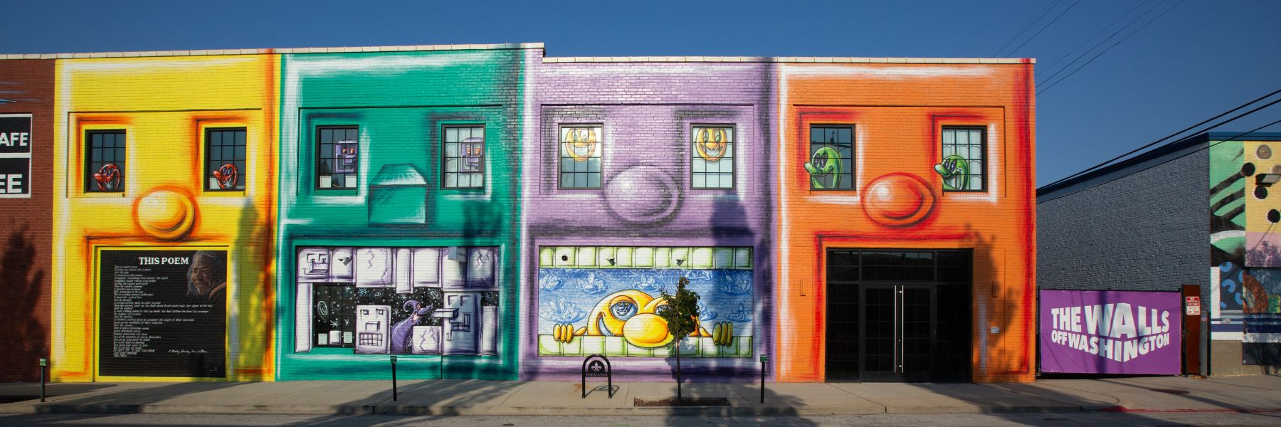 Part of The Walls Off Washington, Kranzbergville, a mural by Kenny Scharf, features four brightly colored buildings that resemble animated faces.