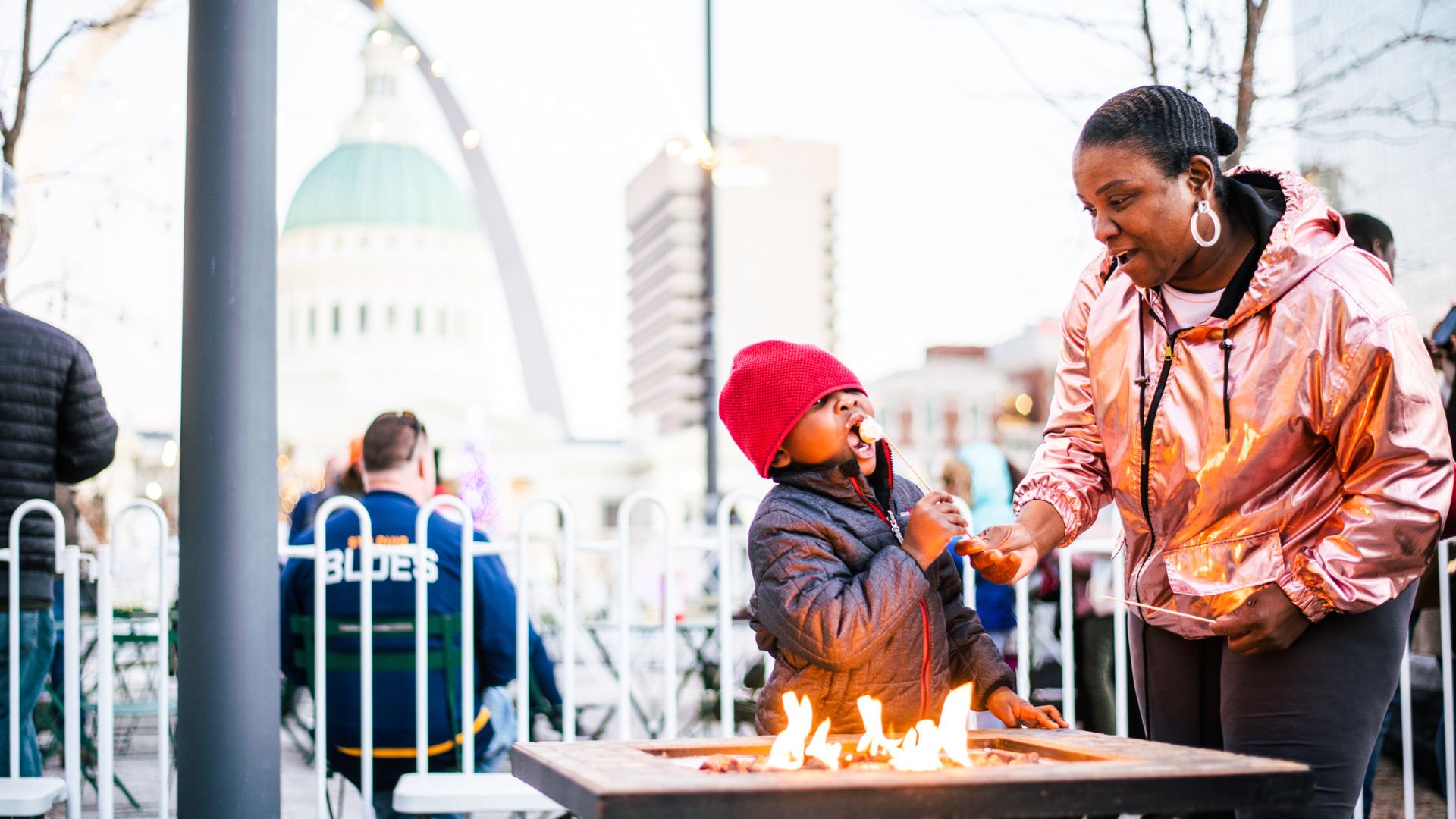 Enjoying holiday fun in St. Louis, a family roasts marshmallows during Winterfest.