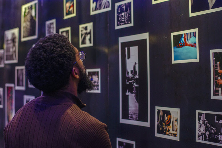 A man looks at photographs on the walls of The Dark Room at The Grandel.