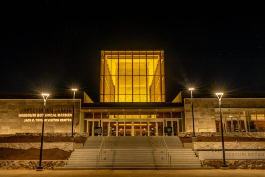 The exterior of the Jack C. Taylor Visitor Center at the Missouri Botanical Garden at night.
