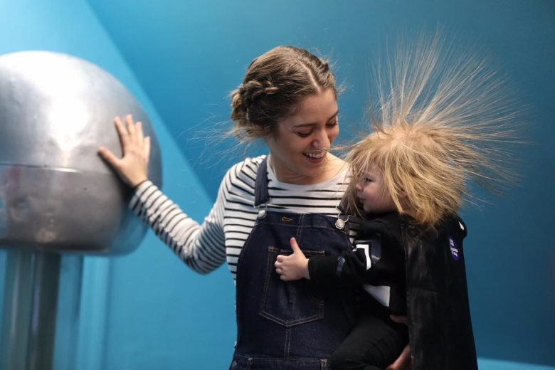 At The Magic House, families with kids make their hair stand up by touching an electrically charged ball.