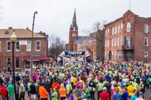 People race through Soulard in the 5K Run for Your Beads during Mardi Gras in St. Louis.