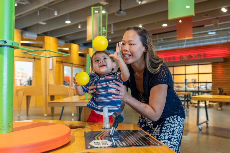 A mother and her young son make balls float in the air at the Saint Louis Science Center.