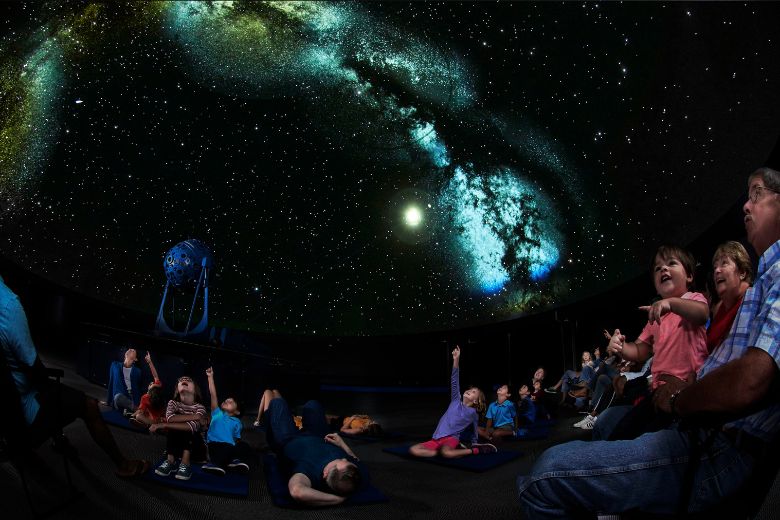 Families explore the night sky at the Saint Louis Science Center.