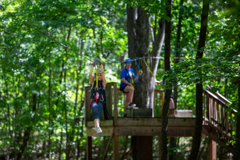 A mom watches as her daughter glides across a zip line at Adventure Valley in St Louis.