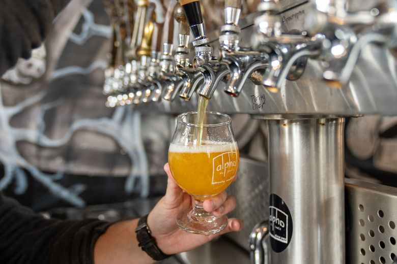 A sour beer pours from a tap at Alpha Brewing Co.