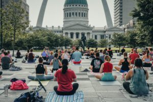 Participants enjoying Sunrise Yoga with Citra Fitness in Kiener Plaza with the Gateway Arch in the background.