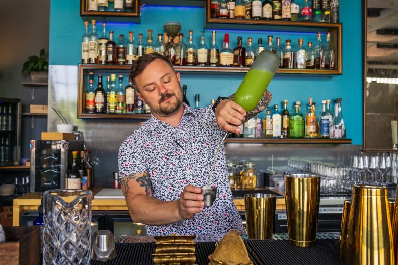 Corey Moszer mixes drinks behind the bar at The Lucky Accomplice.