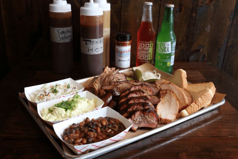 Sugarfire Smoke House serves platters of brisket, baked beans, mashed potatoes and coleslaw.