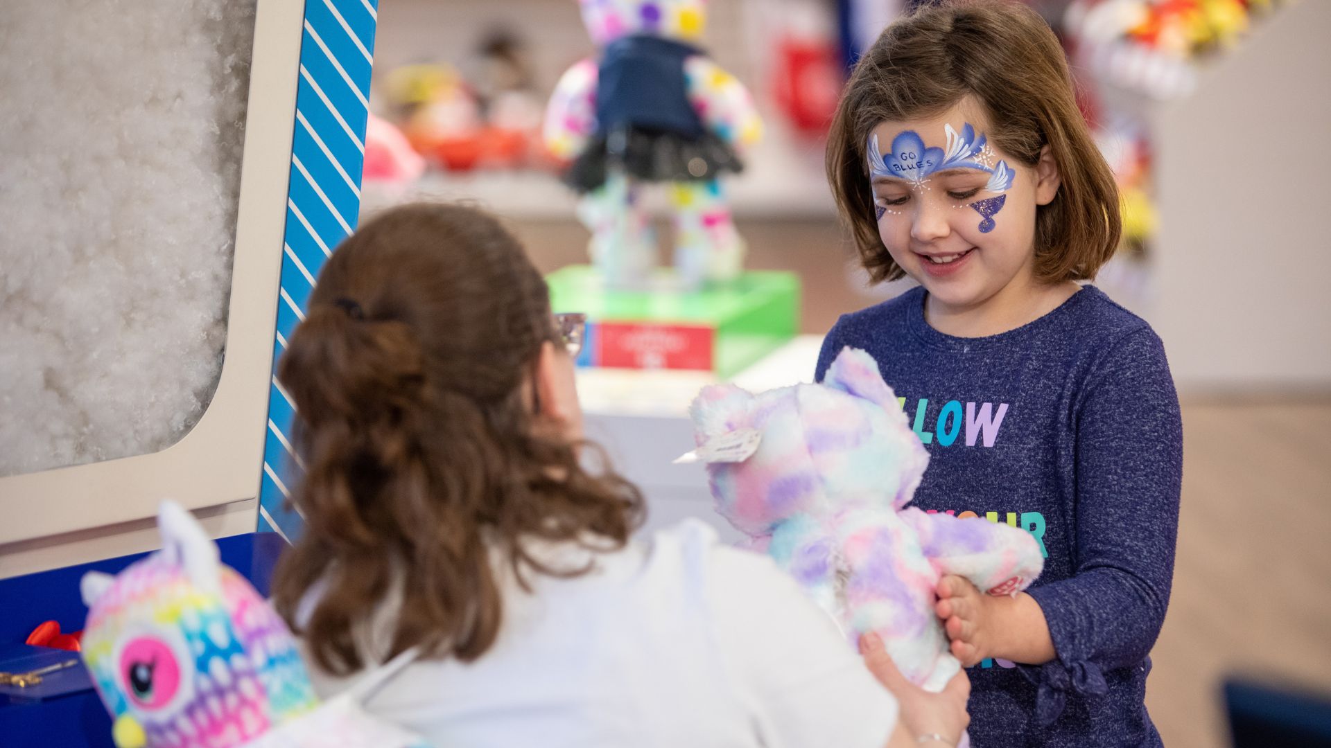 A young girl builds a bear at Build-A-Bear Workshop.