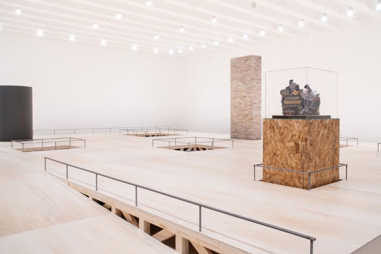 Kahlil Robert Irving's exhibition at the Mildred Lane Kemper Art Museum features a plywood platform with sculptural pieces protruding from it.