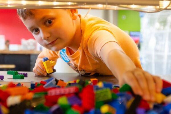 A kid enjoys STEAM activities like playing with Legos at MADE for Kids in St. Louis.