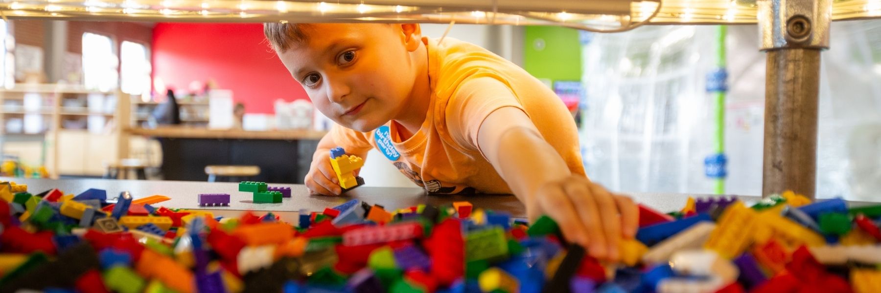 A kid enjoys STEAM activities like playing with Legos at MADE for Kids in St. Louis.