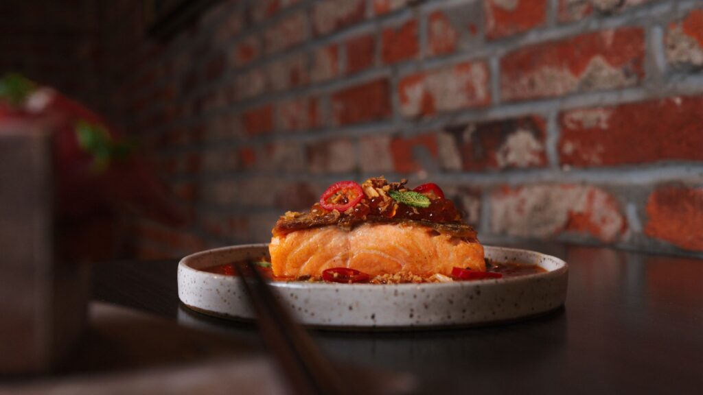 At Indo, chef Nick Bognar serves crispy skin king salmon with tom kha coconut broth and chive oil.