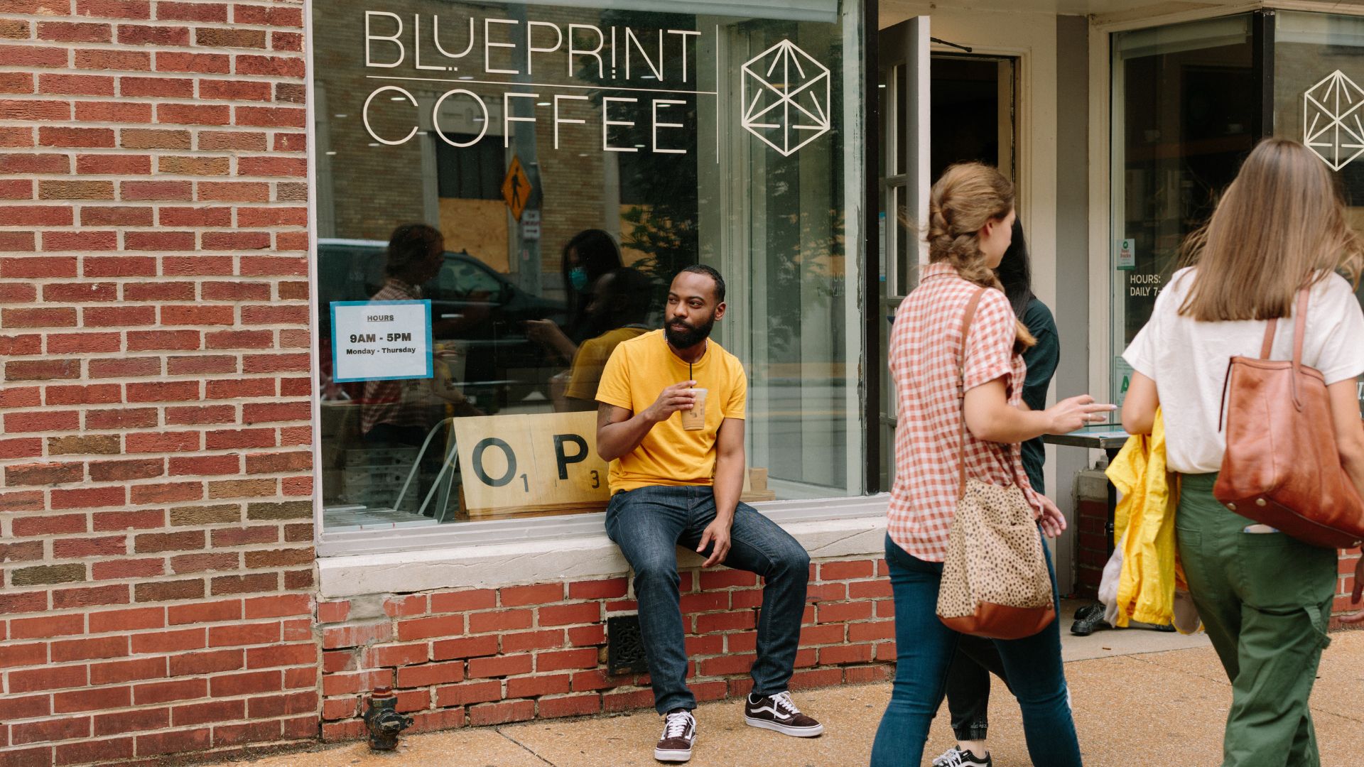A customer enjoys a specialty coffee outside of Blueprint Coffee in the Delmar Loop.