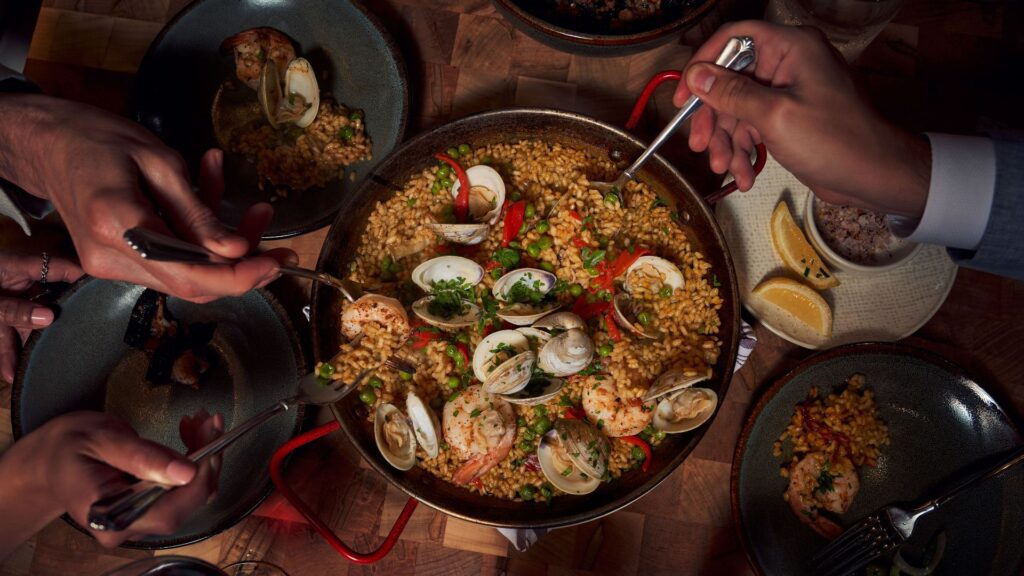 Guests dig into a seafood paella at Idol Wolf inside 21c Museum Hotel St. Louis.