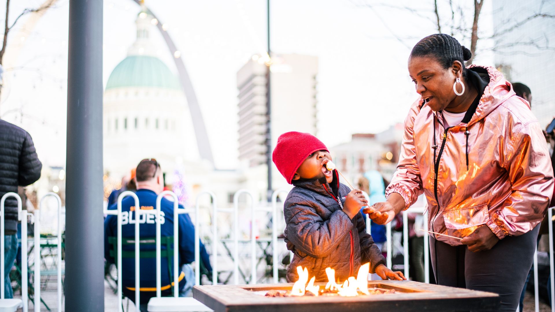 A family roasts marshmallows in downtown St. Louis during Winterfest.