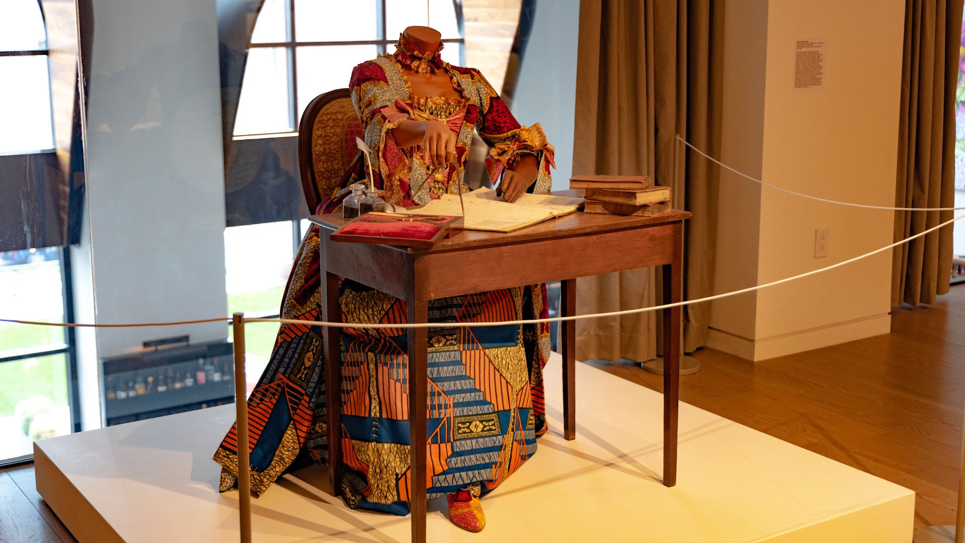Yinka Shonibare CBE RA's The Marquise du Châtelet features a life-size headless woman sitting at a desk.