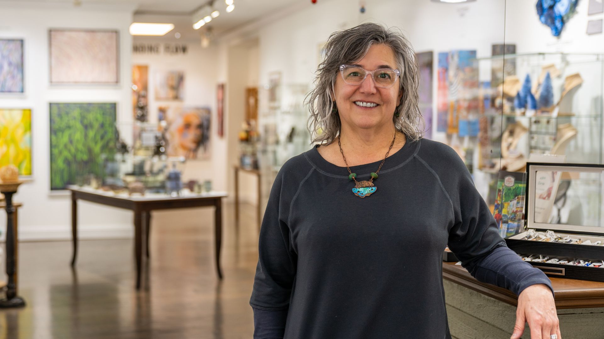 Mary Martin, owner of Green Door Art Gallery, poses in the beautiful space.