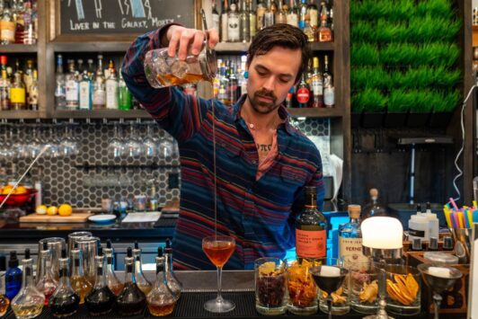 A bartender pours a craft cocktail at Blood and Sand.