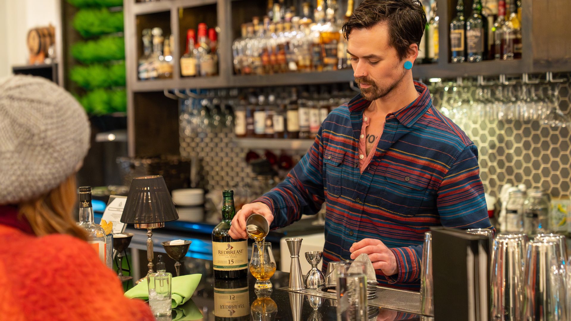 A bartender pours a craft cocktail at Blood and Sand.