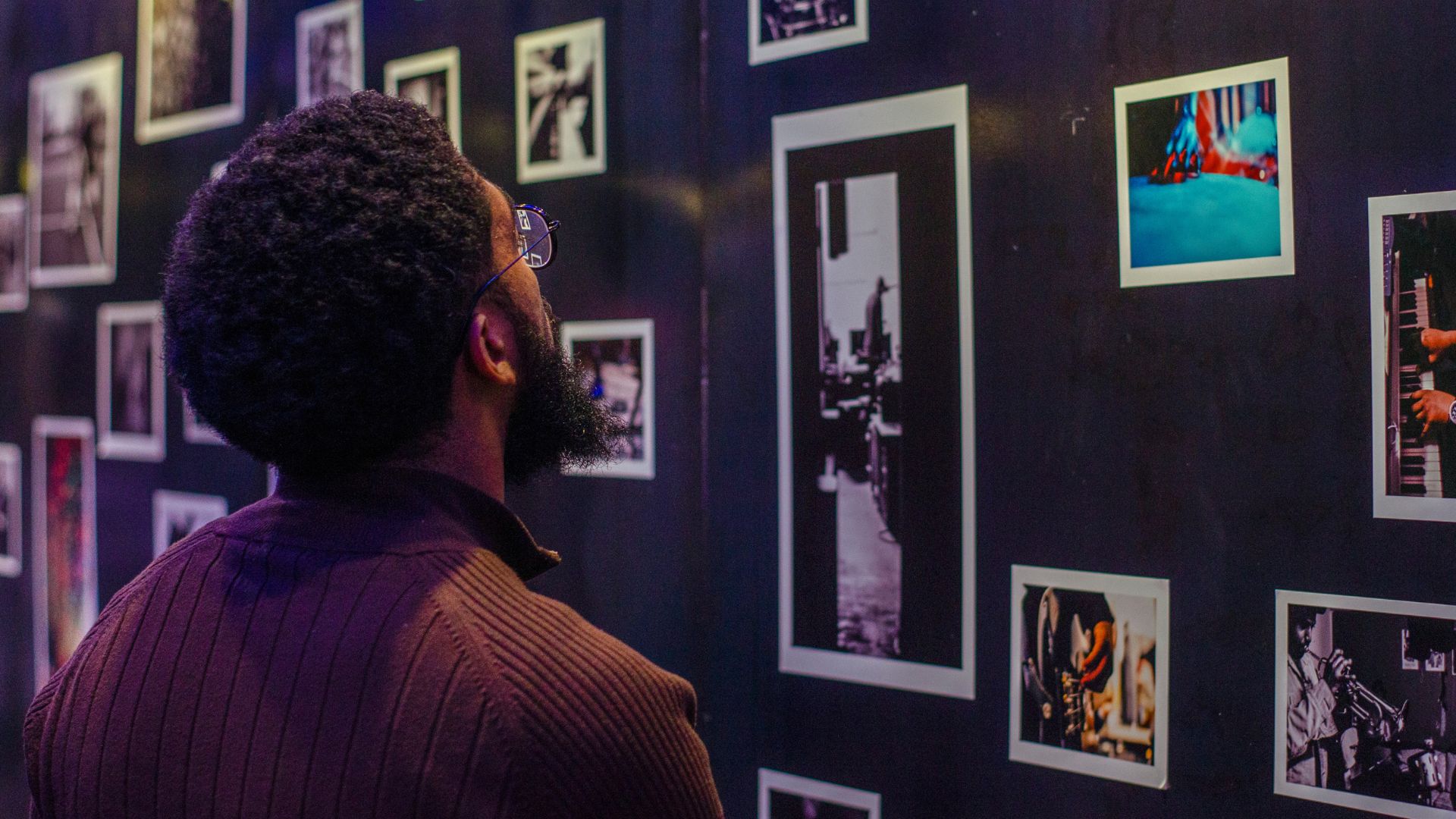 A man views a photography exhibit at The Dark Room at The Grandel.