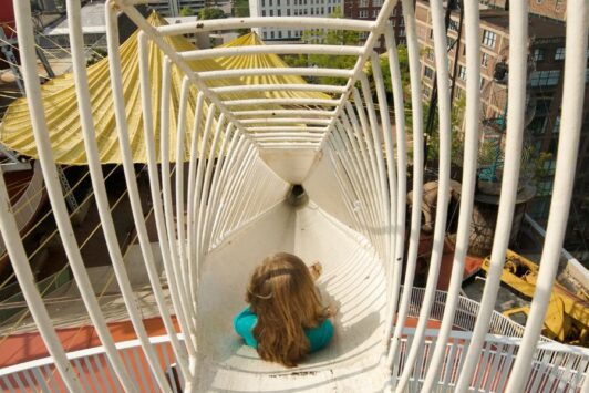 A girl rockets down a rooftop slide in St. Louis.