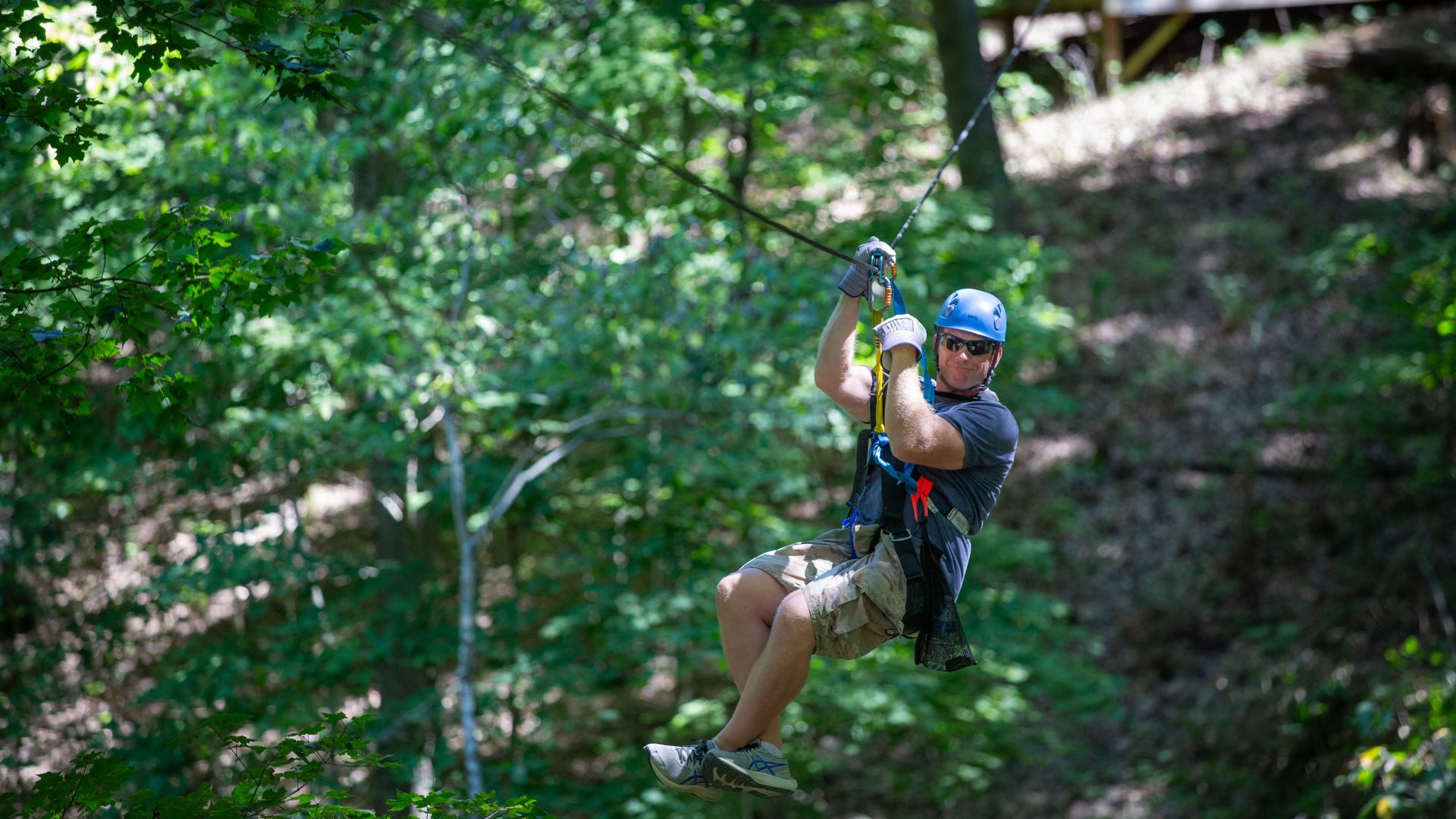 A man zip lines through the woods at Adventure Valley in St. Louis.