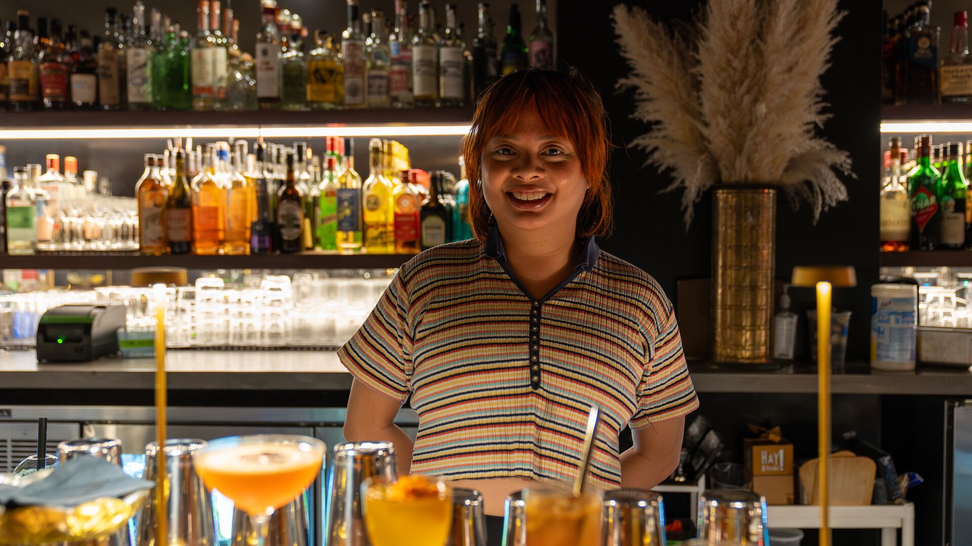 Fionna Gemzon mixes drinks behind the bar of None of the Above.