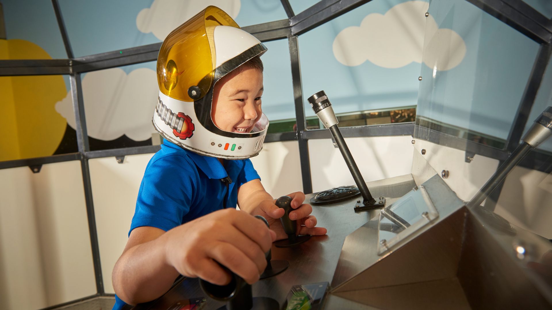 A young boy pretends to be an astronaut at the Saint Louis Science Center.