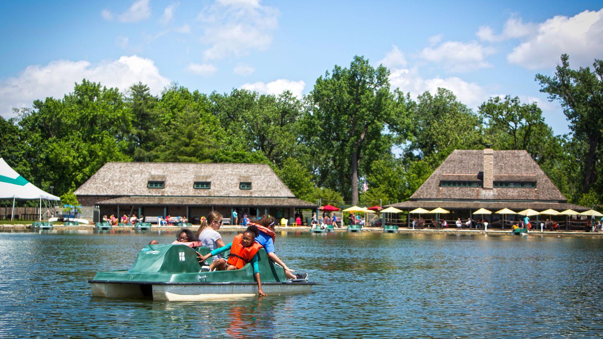 A family uses a paddle boat to explore the Emerson Grand Basin in Forest Park.