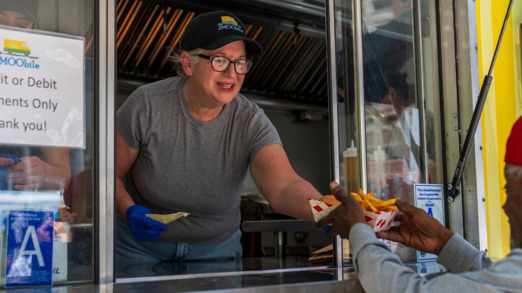 A woman serves tallow fries from The MOObile food truck.
