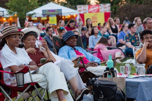 A diverse audience watches a performance during the St. Louis Shakespeare Festival.