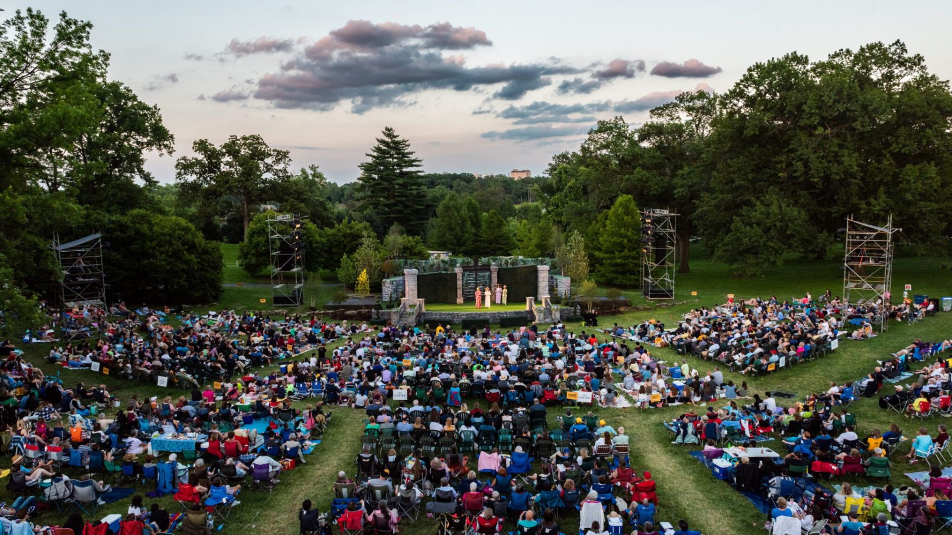 A diverse audience watches a performance during the St. Louis Shakespeare Festival.