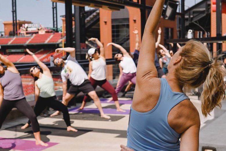 People do yoga on the rooftop of Ballpark Village in St. Louis.