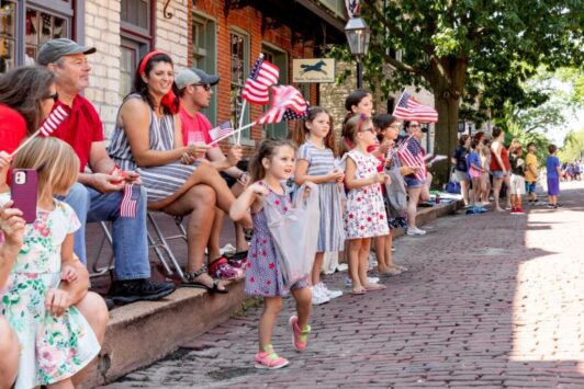 Kids wave American flags during Saint Charles Riverfest.