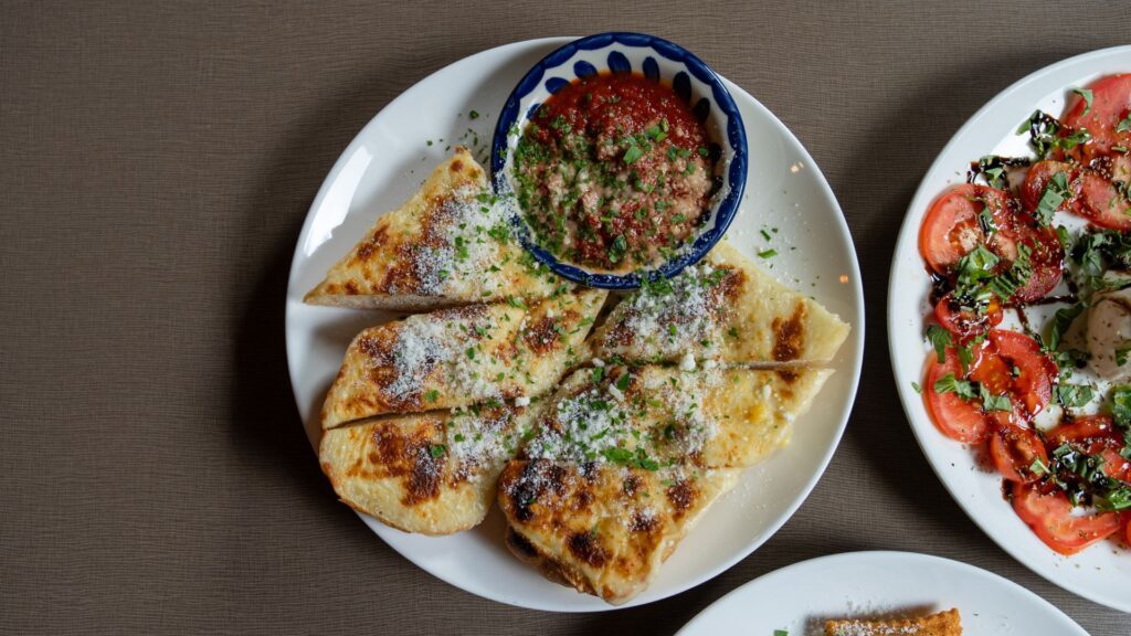 Start a meal at Anthonino’s Taverna with garlic cheese bread and caprese salad.