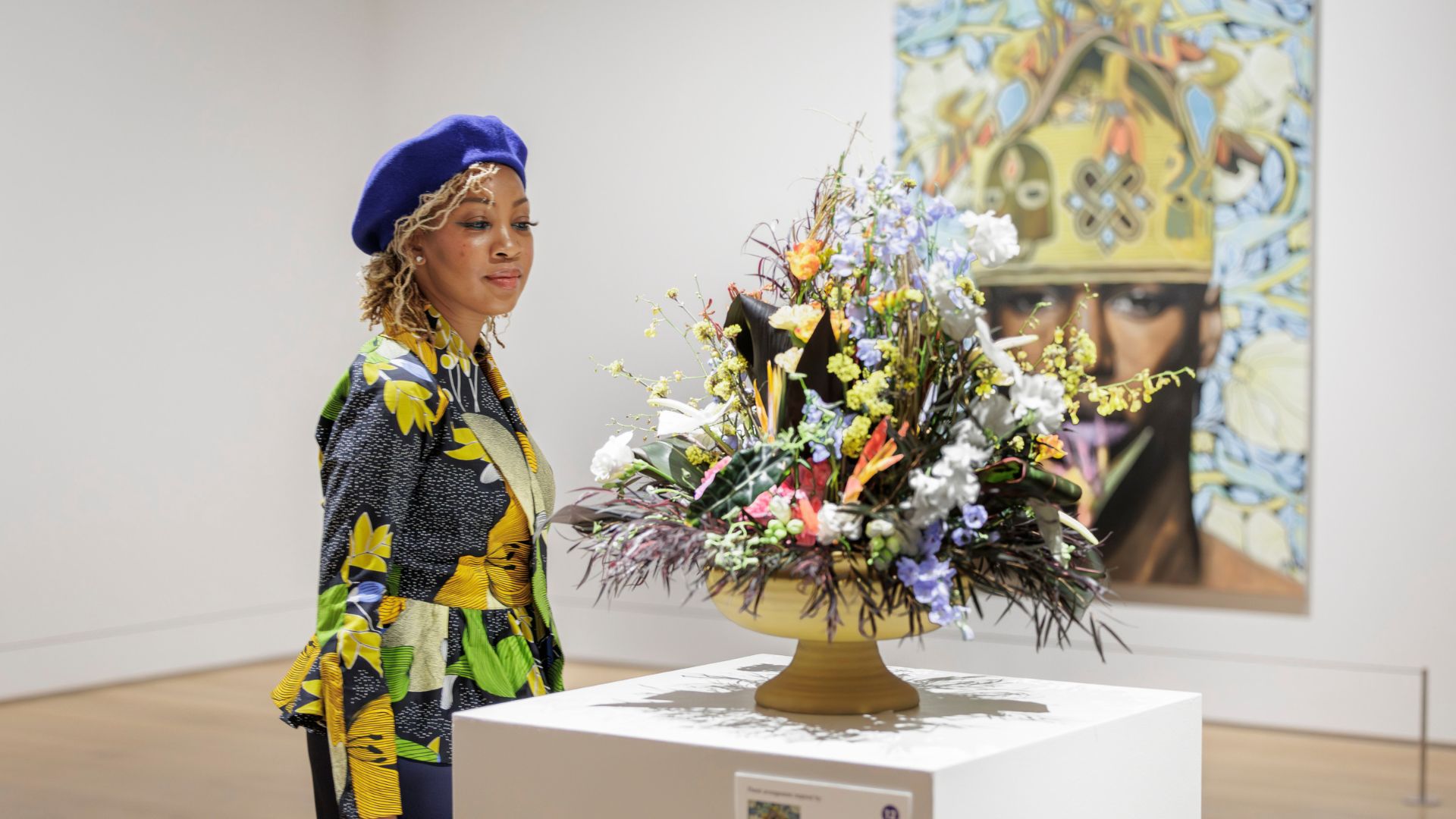 A well-dressed woman admires a bouquet of flowers during Art in Bloom at the Saint Louis Art Museum.