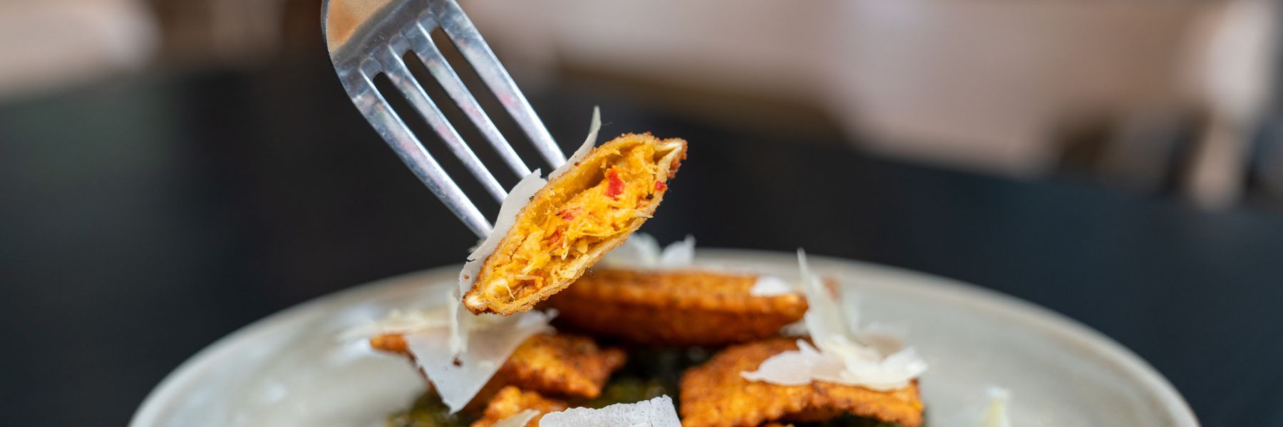 A diner digs into the artichoke toasted ravioli at Katie's Pizza and Pasta Osteria.