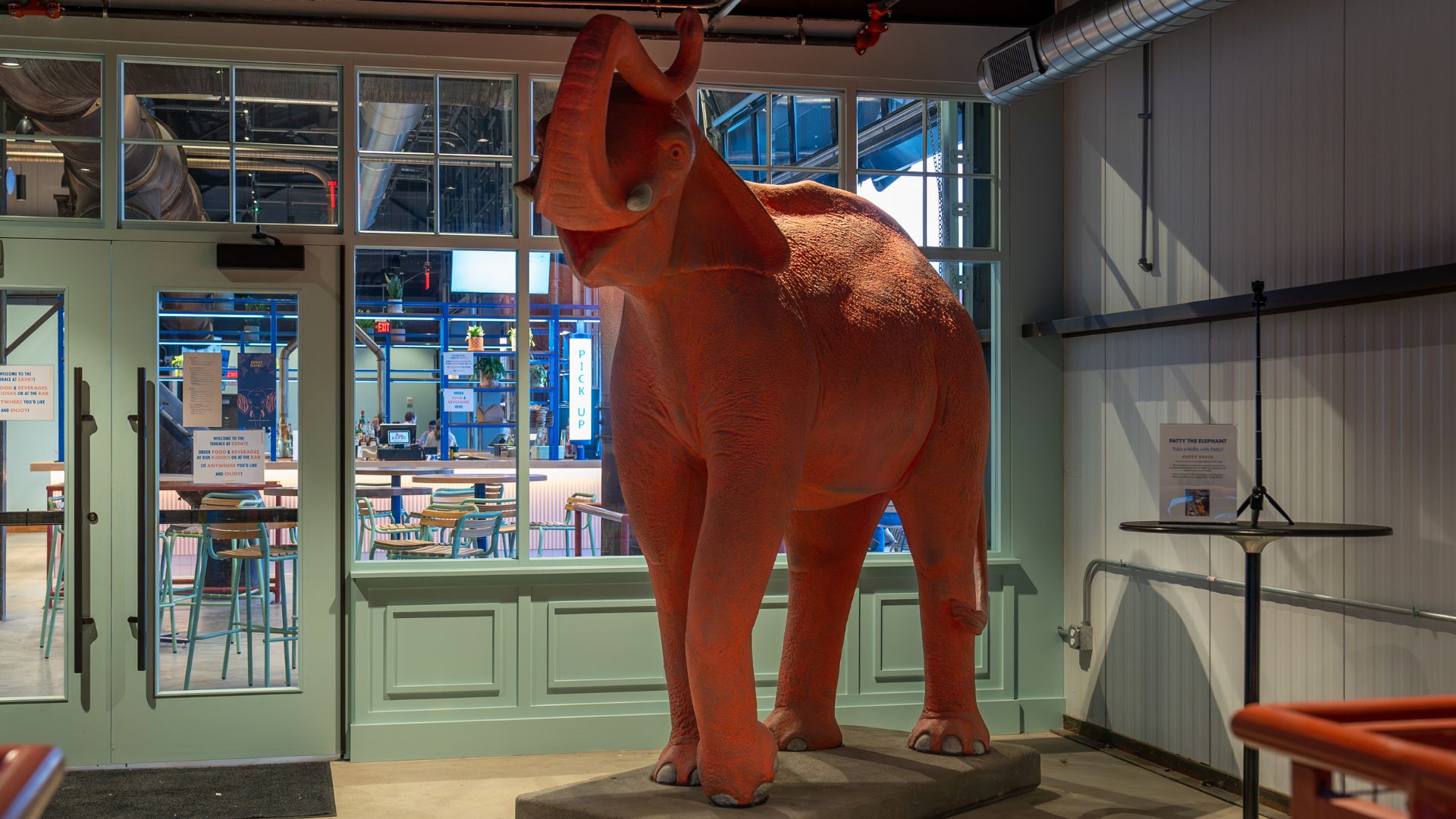 A concrete sculpture of a pink elephant welcomes guests.