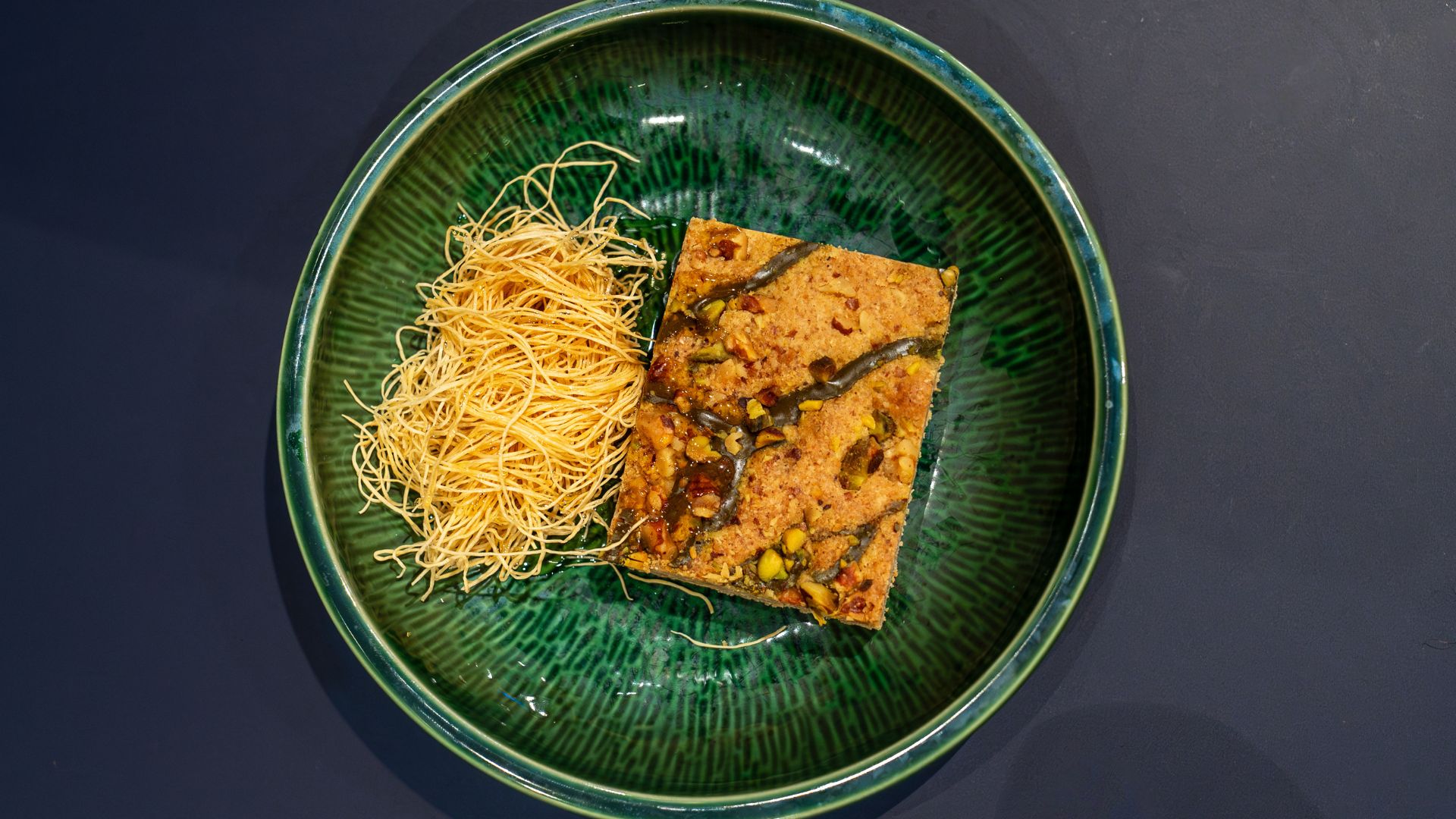 This baklava brownie comes with honey and pistachios.