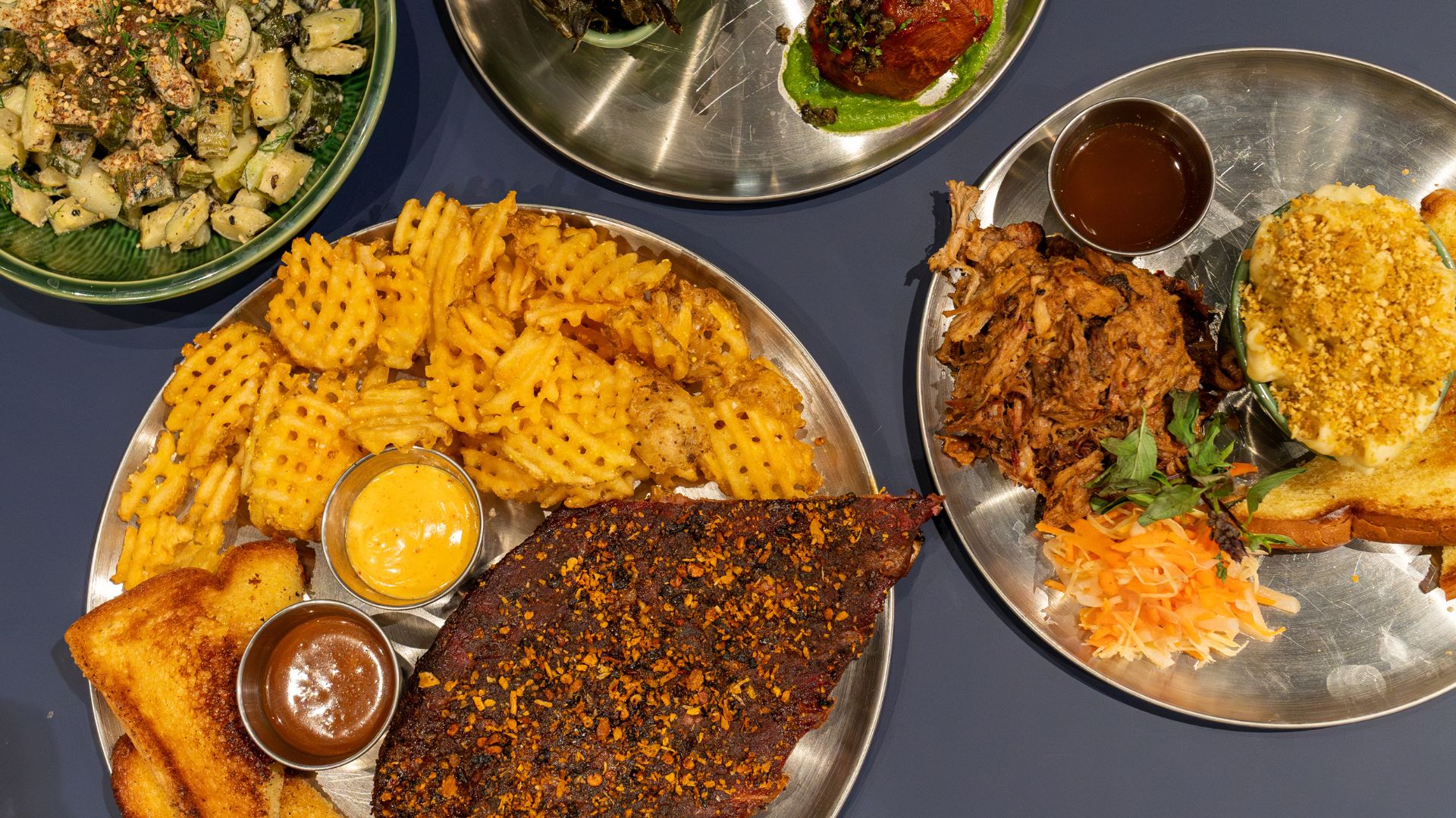 A spread at Expat BBQ includes St. Louis-style ribs, pulled pork and roasted sweet potatoes.