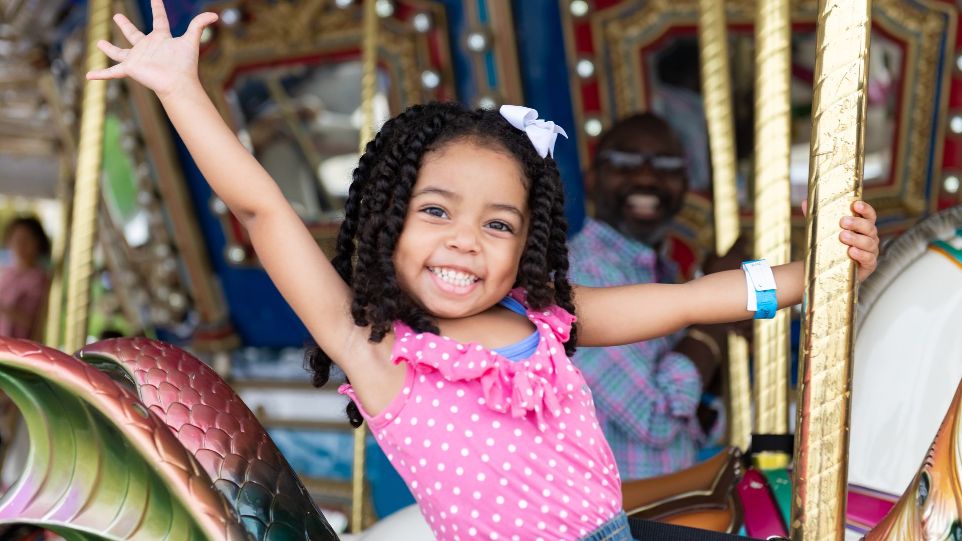 A little girl gives a big smile aboard the carousel at St Louis Union Station.