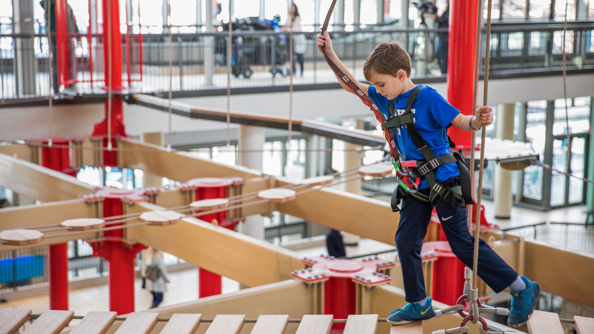 A young boy completes the three-story-high indoor ropes course at Union Station.