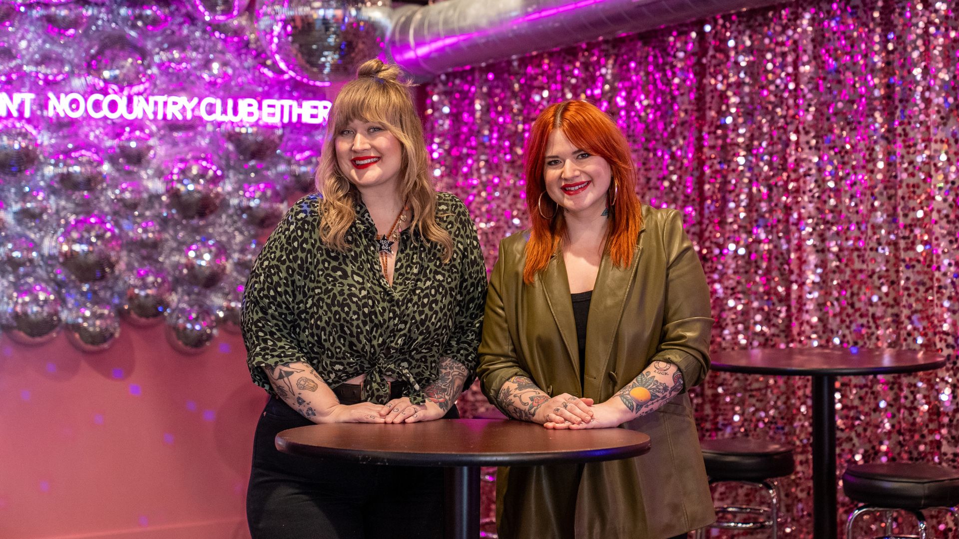 Susan Logsdon and Amanda Helman strike a pose on the dance floor of their disco dive bar, Hidden Gems.