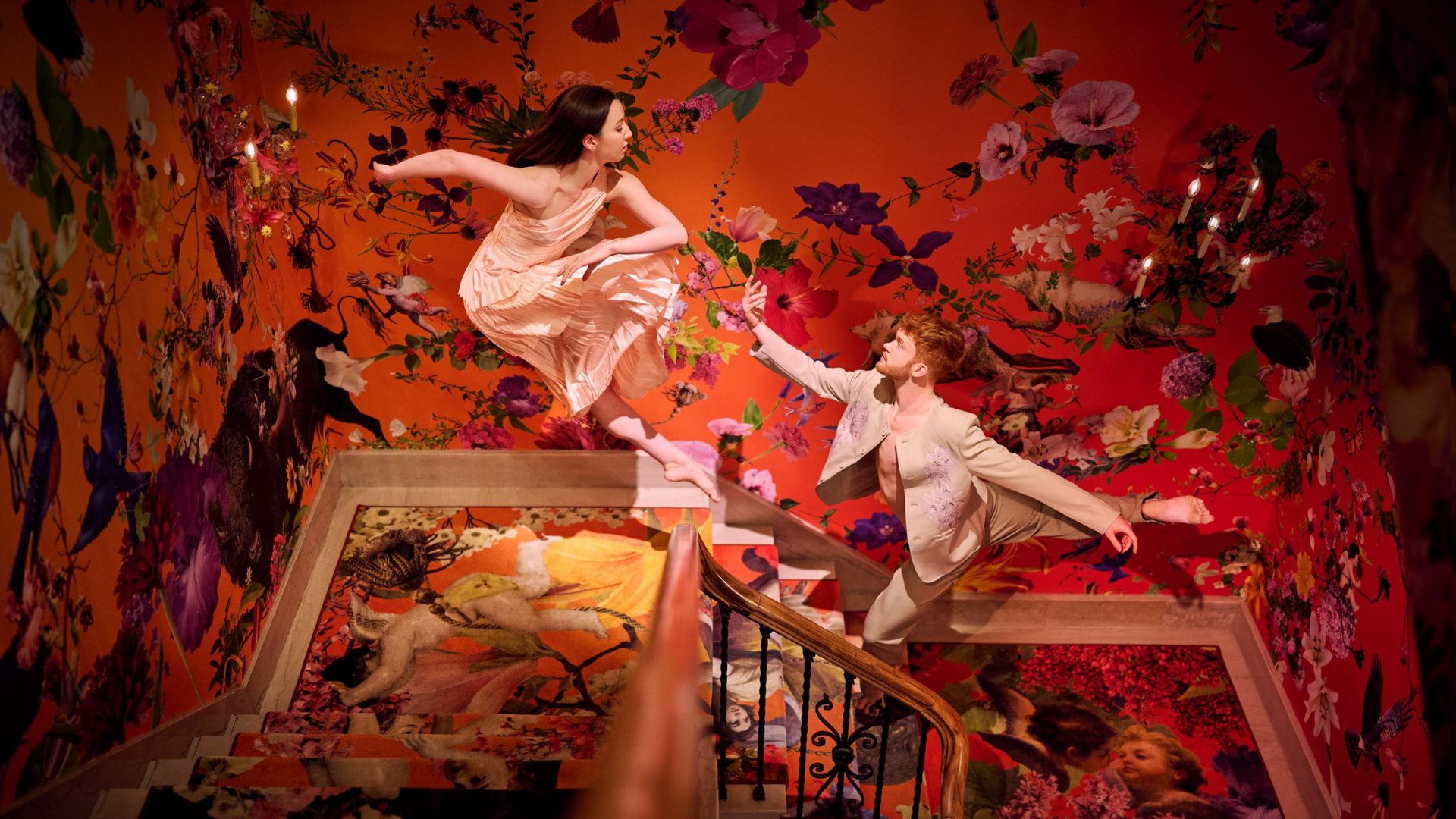 Two dancers strike poses in the colorful stairwell of 21c Museum Hotel St Louis.