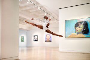A beautiful dancer does a leap in an art gallery at 21c Museum Hotel St Louis.