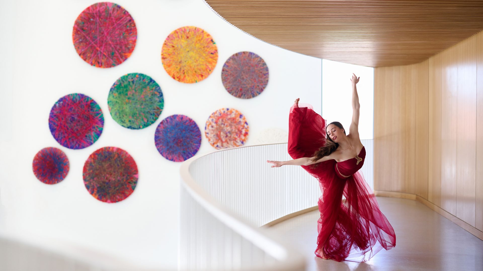 A dancer in a flowing red costume strikes a pose at Powell Hall in St Louis.